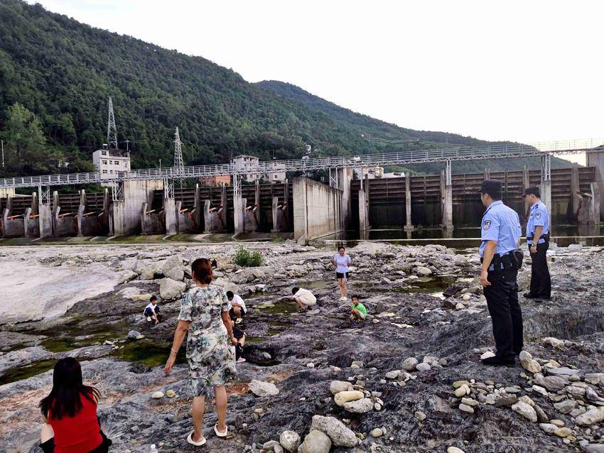 民警在河边劝导戏水儿童（通讯员刘诗雨 摄）