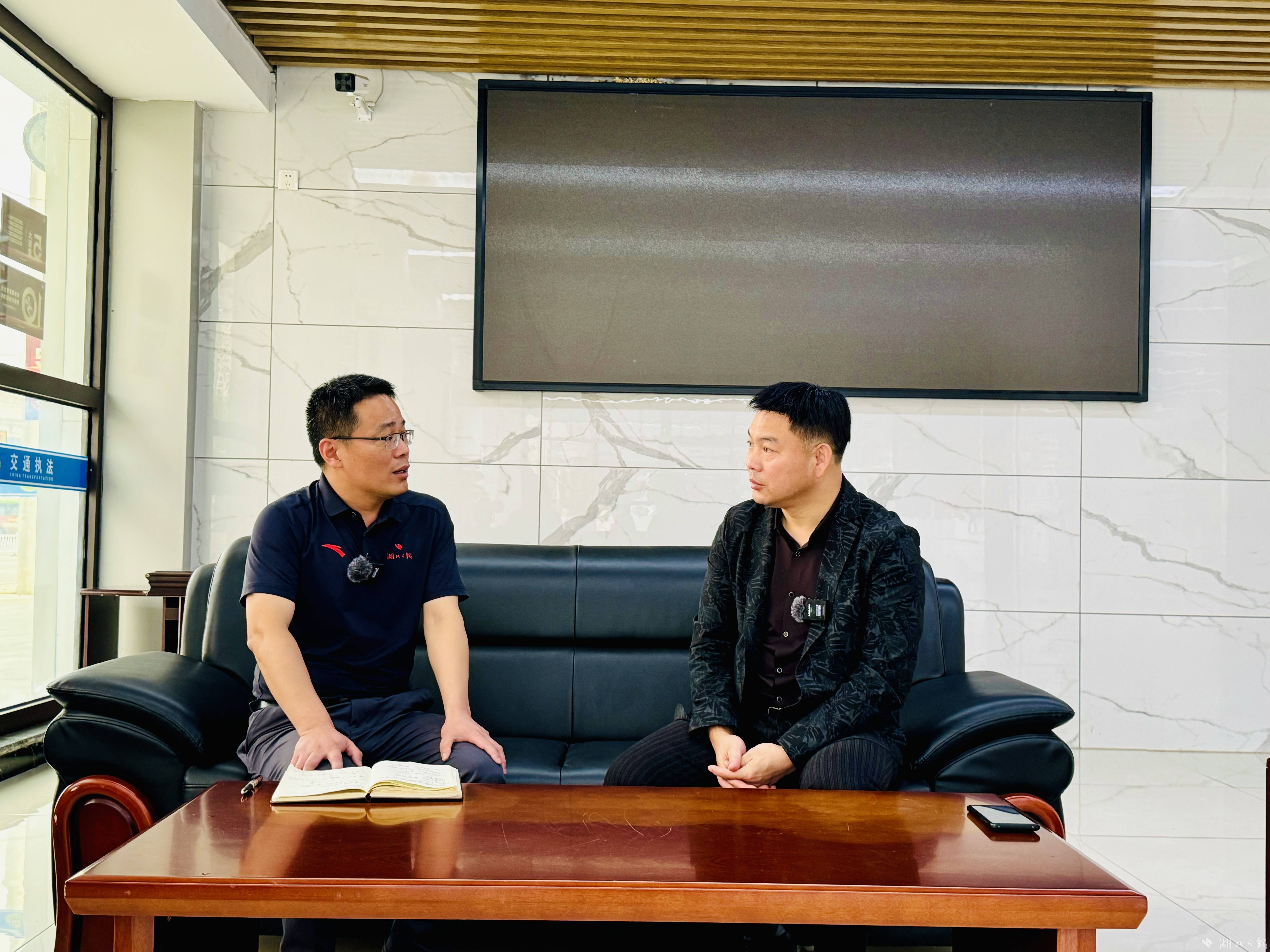 10月10日上午，湖北日报全媒记者汪洋（左）在通城面对面采访“白车侠”杜志军（右）。