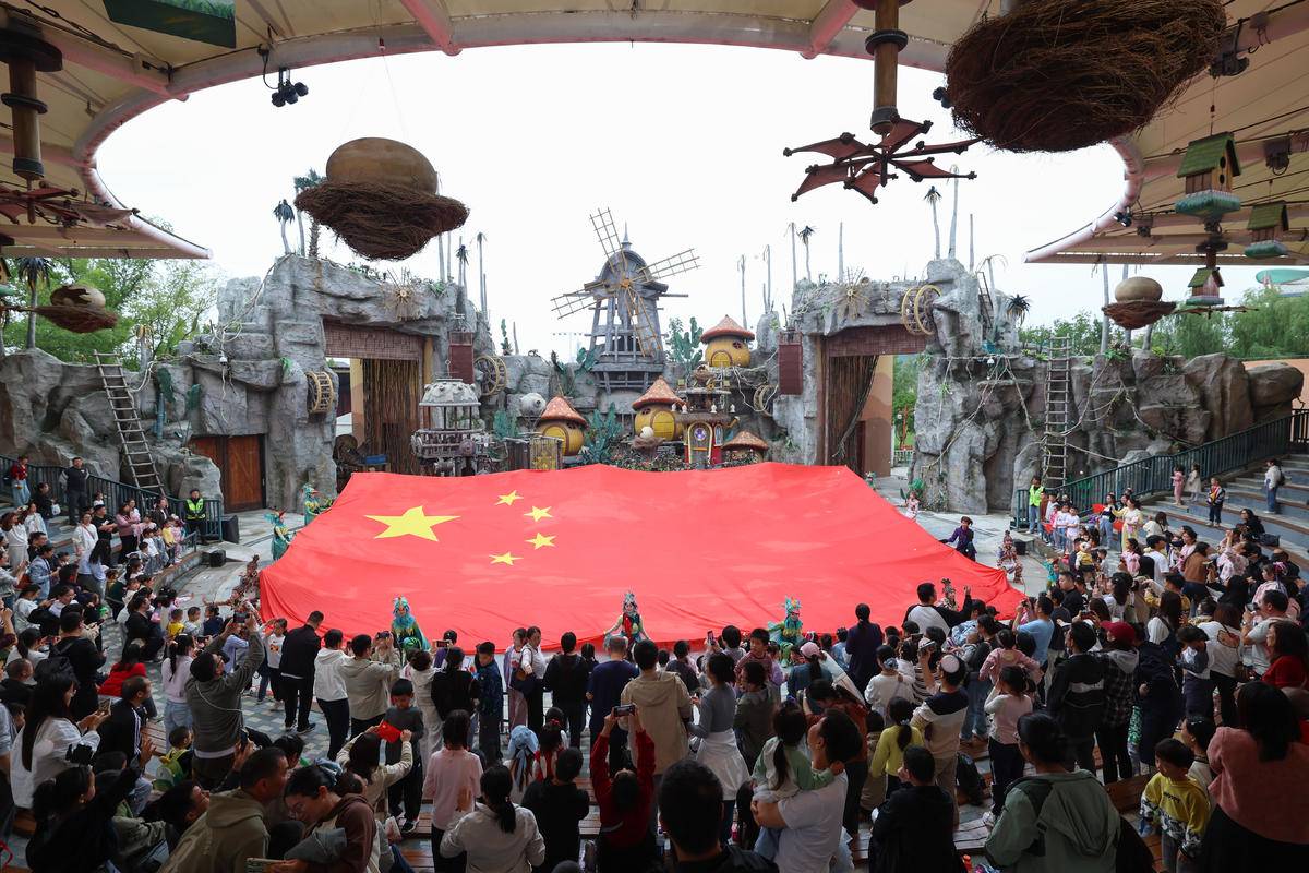 游客在襄阳市华侨城奇幻度假区参加“我和国旗合影”快闪活动。