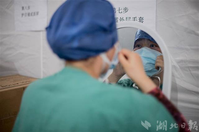 2月24日晚上，一位医疗队员正在对着镜子检查口罩