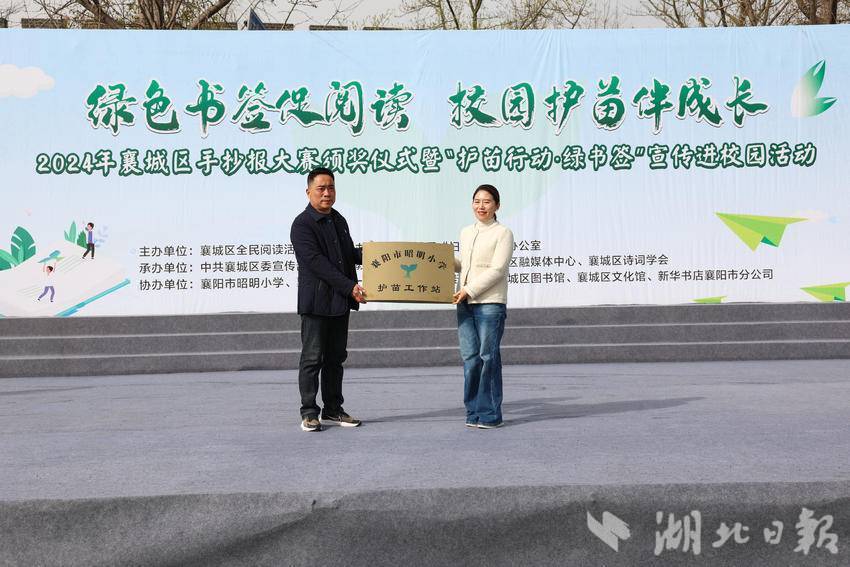 襄城区政府副区长朱崎锦向昭明小学党总支书记张自力授牌。
