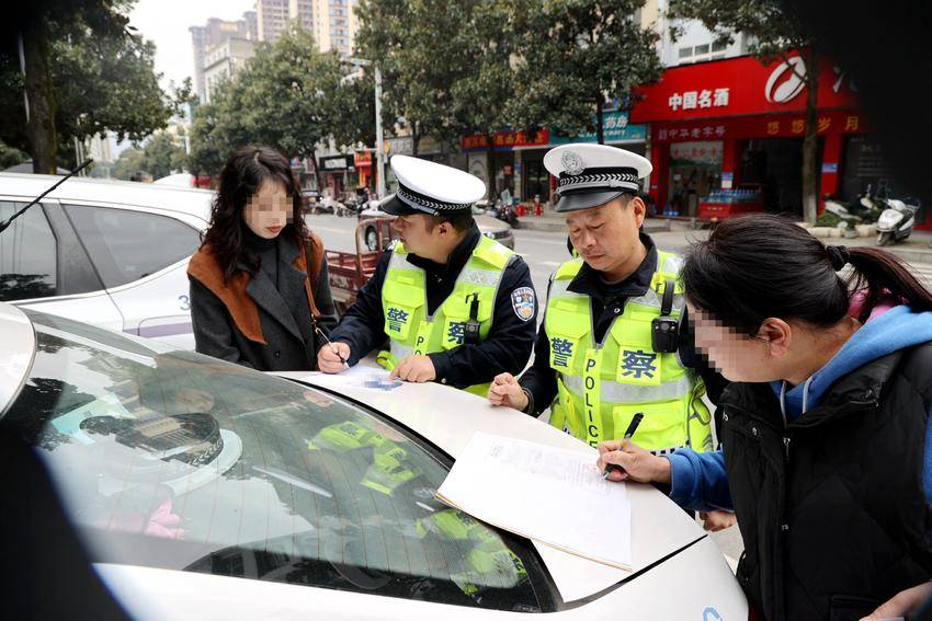 交警在给违法上路机动车驾驶员开据马路学堂学习单。