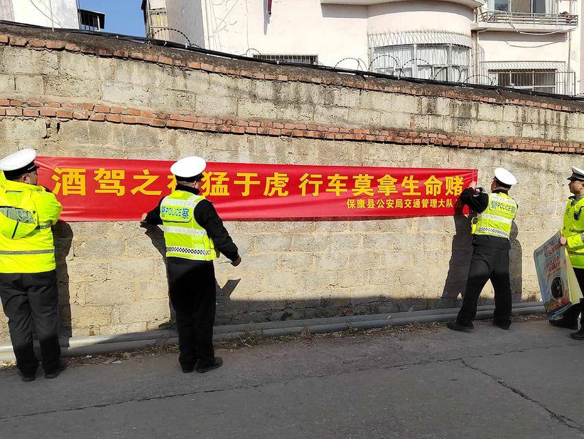 交警在悬挂交通安全宣传条幅。