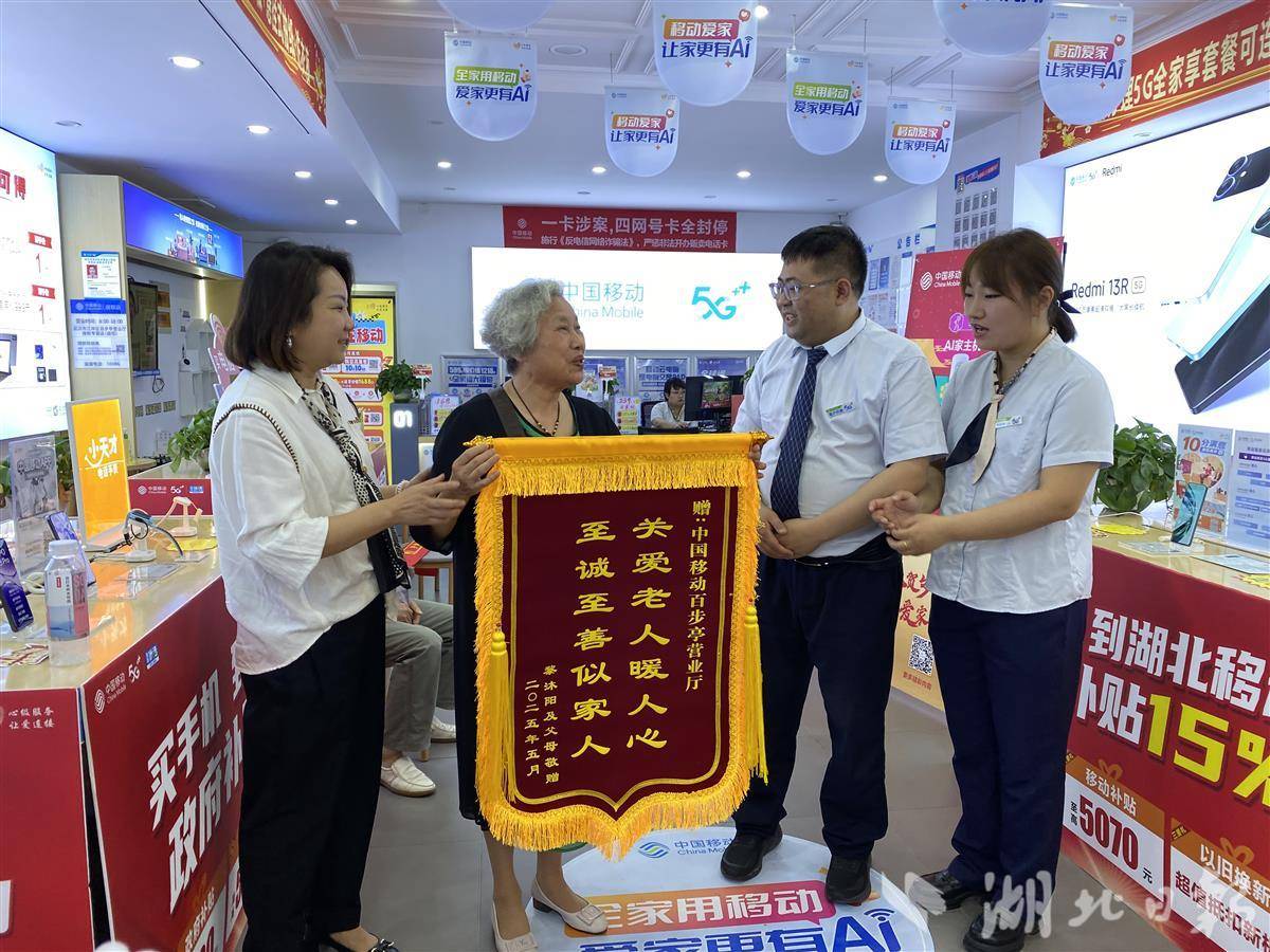 5月23日，在中国移动武汉市江岸区百步亭营业厅，毛伶俐在家人的陪伴下，给营业厅工作人员送上锦旗。（记者刘天纵摄）