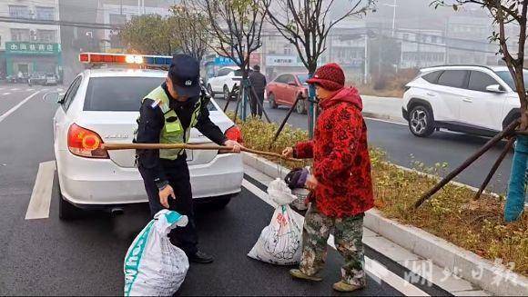 浓雾锁国道，巡逻交警安全护送挑担赶集的老大娘