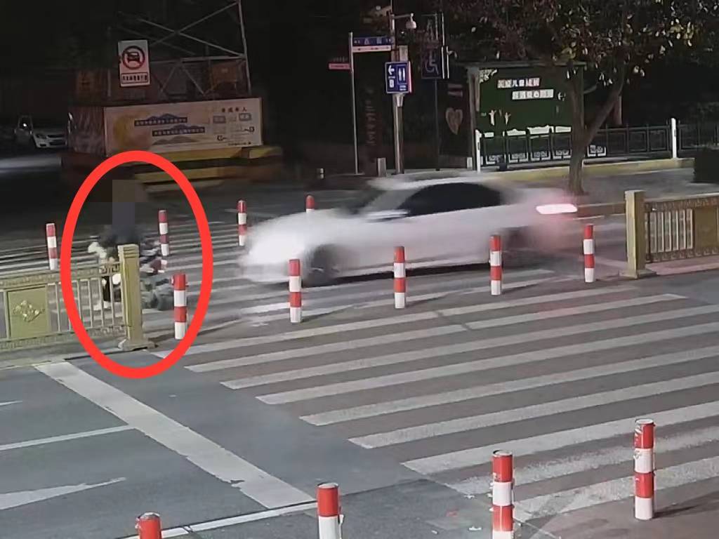 女子骑电动车经过路口