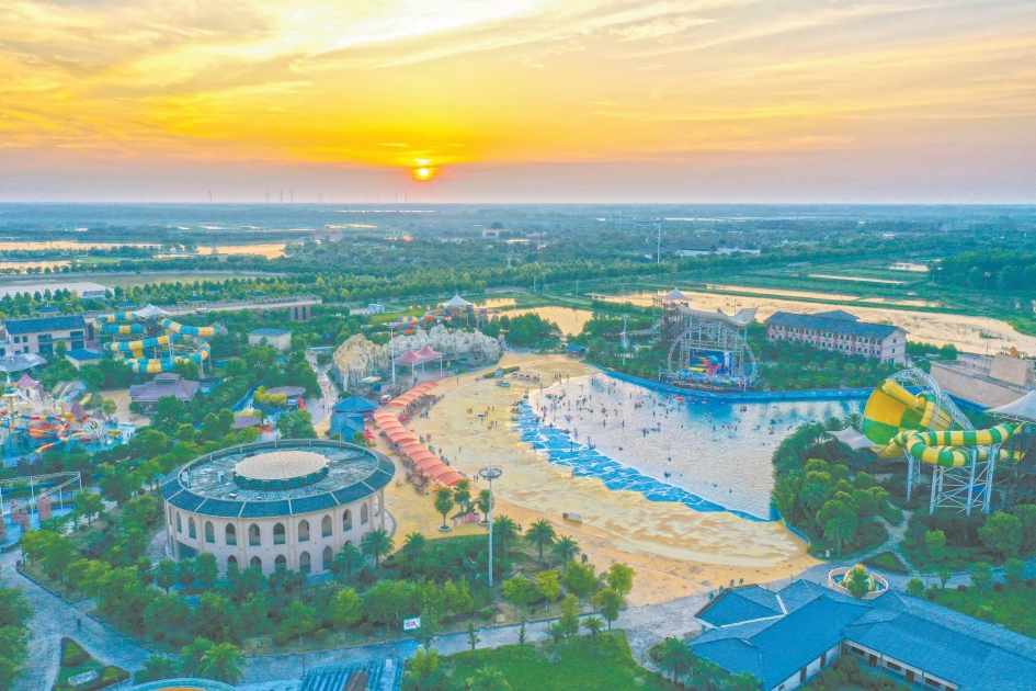 图为7月31日，晚霞漫天，市民游客在荆楚云天海世界戏水纳凉。