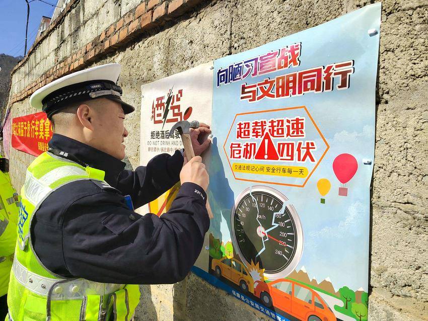 交警在张贴交通安全主题海报。