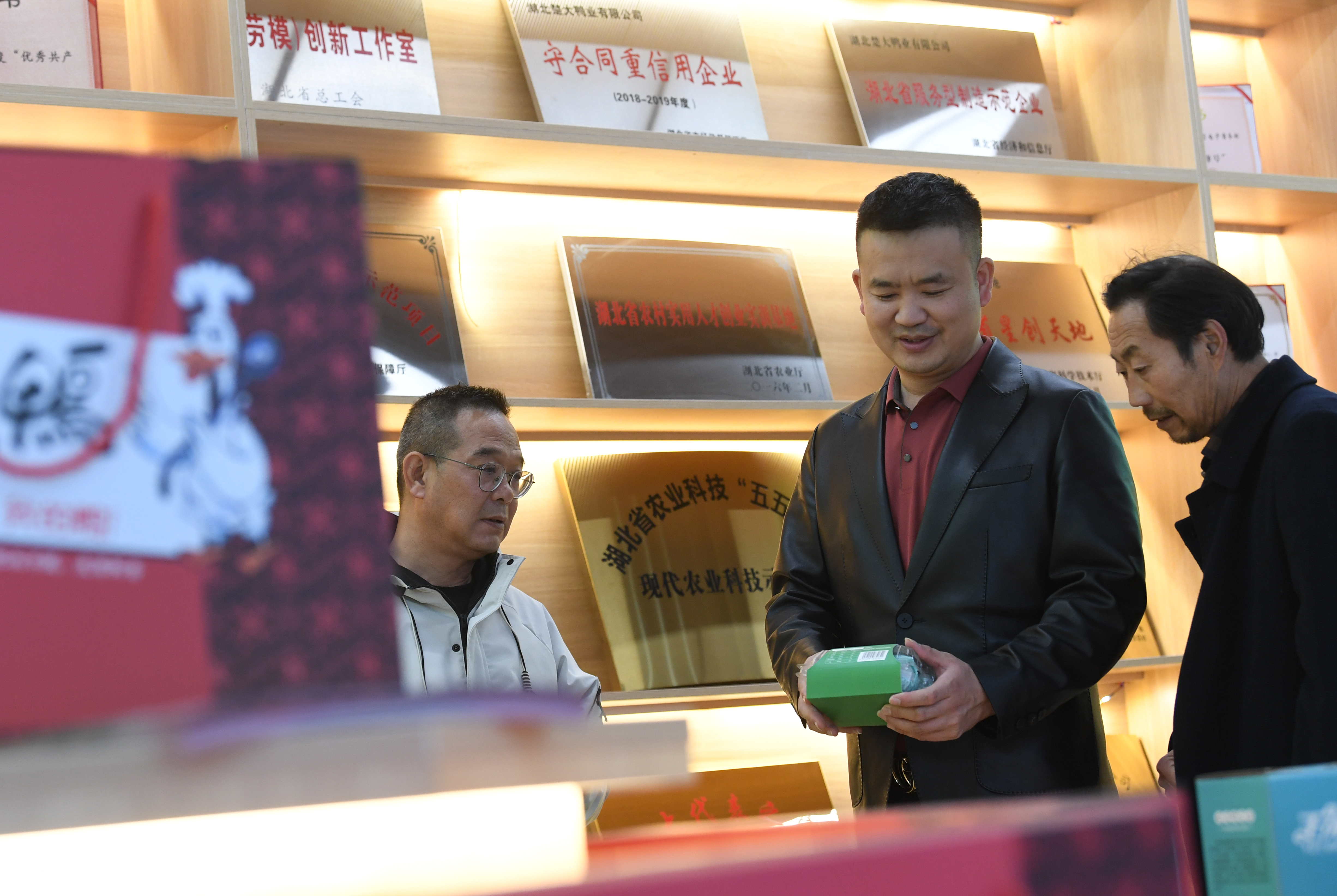 楚大鸭业总经理任乐乐（中）和员工探讨电商平台发展前景 。（湖北日报全媒记者田悦 通讯员李锋、谢勇 摄）
