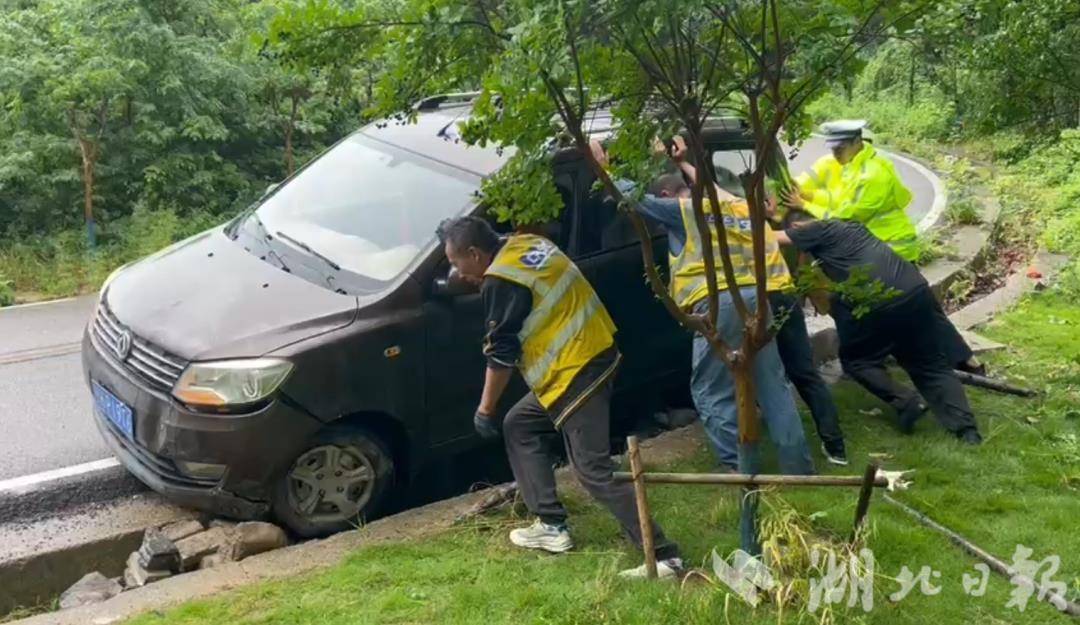 荆门民警在开展山区道路巡查时，发现圣境山路往一级平台路段有一辆小车掉入路边沟渠，执勤民辅警合力推车，助车辆脱困。