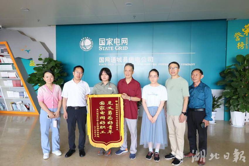 雨夜被撞老人杨鼎新（左四）携全家送来锦旗。