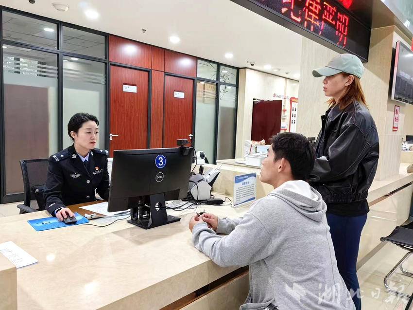 胡孝睿（左一）为群众办理出入境业务