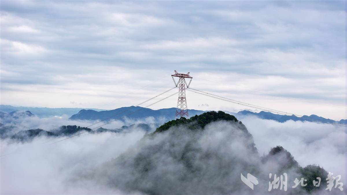 恩施市红土乡崇山峻岭上，金上至湖北±800千伏特高压直流工程输电线路云雾缭绕，壮观美丽。（邹小民摄）