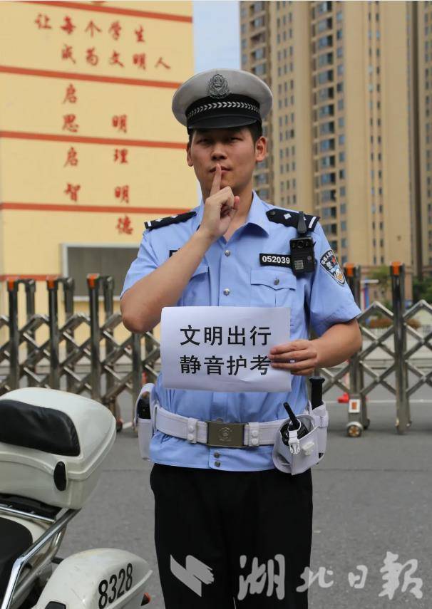 ▲荆州交警在考点门前倡导“静音护考”。