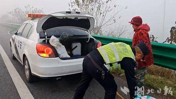 浓雾锁国道，巡逻交警安全护送挑担赶集的老大娘