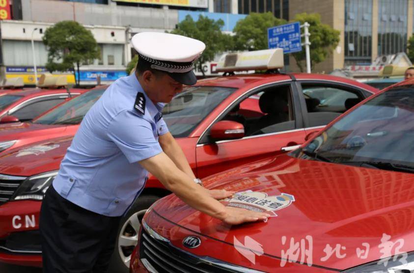 ▲荆州交警为“爱心送考”车辆粘贴标识。