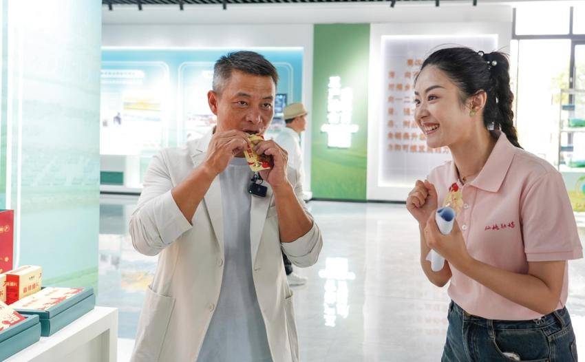 图为奥运冠军李小双在直播时品尝黄鳝休闲食品。摄影 邓娟