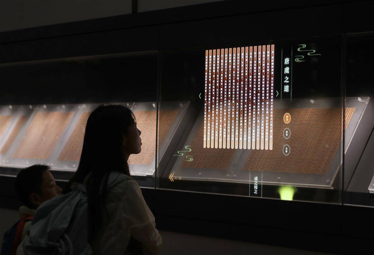 图为2025年10月2日，湖北省荆门市博物馆“惊世典籍·郭店楚简”展厅内，游客驻足凝视泛黄的竹简，耳畔萦绕着先秦儒道经典的故事讲解。.jpg