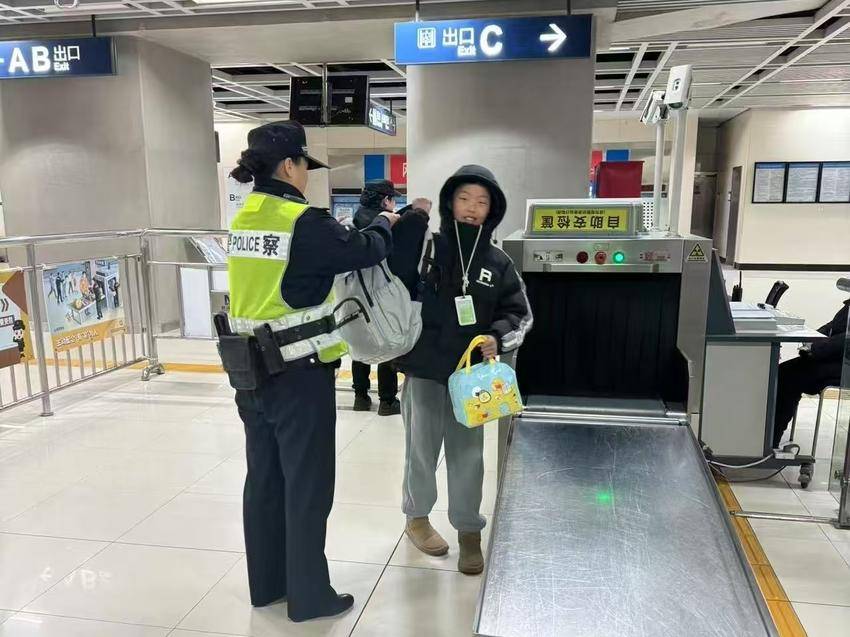 轨道民警为过安检学生背上书包