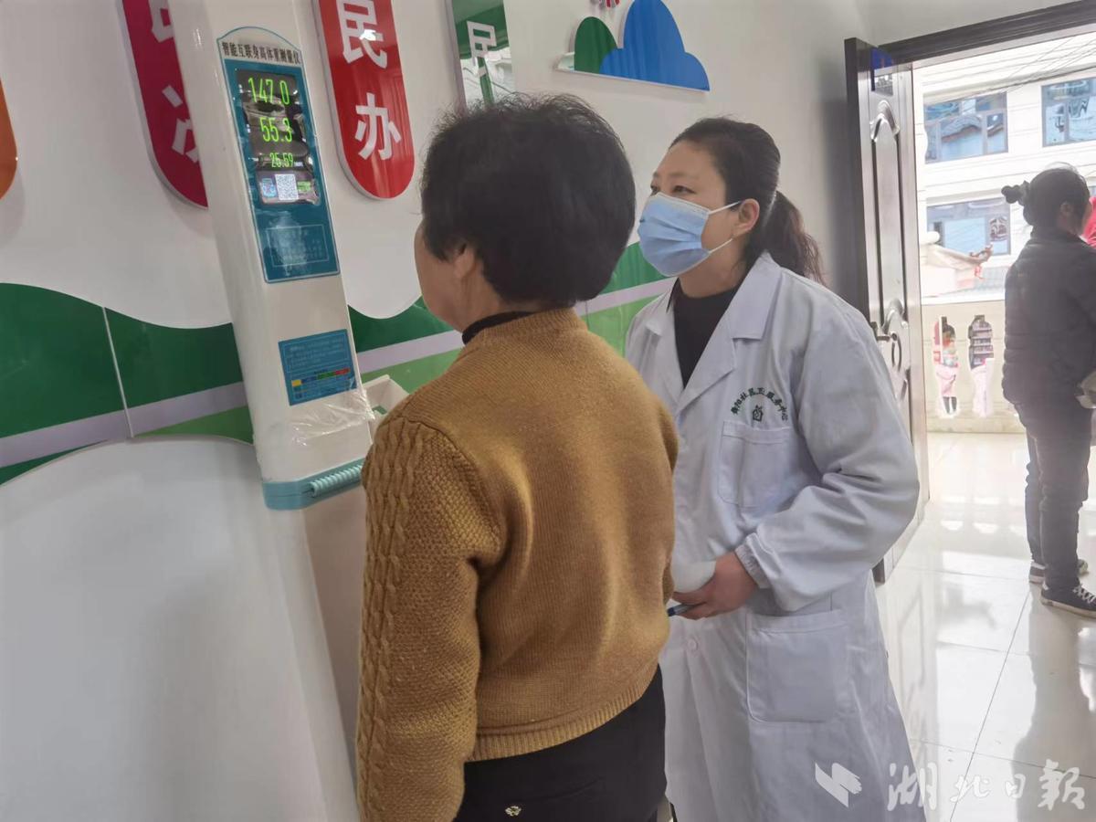 上图为医务人员为女性居民测量身高体重