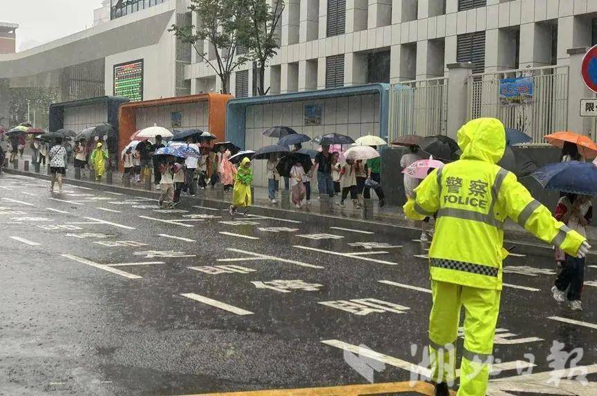 荆门市实验小学门口，荆门交警雨中坚守“护学岗”，为学生们撑起交通安全“保护伞”。