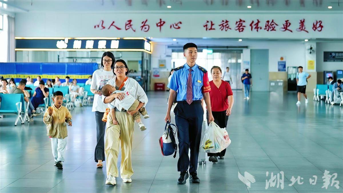 襄阳火车站工作人员帮旅客提拿行李。通讯员 刘娟 摄