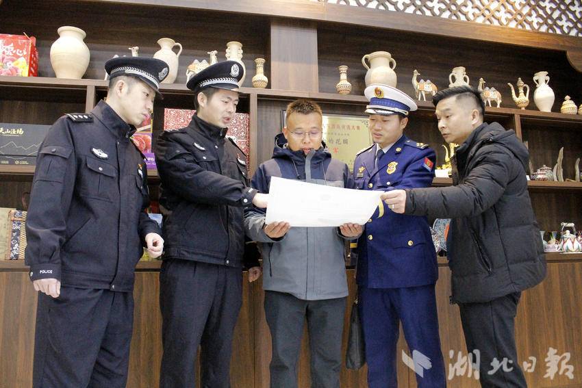 民警主动上门将办理好的旅店业《综合许可证》送到旅馆负责人手中。