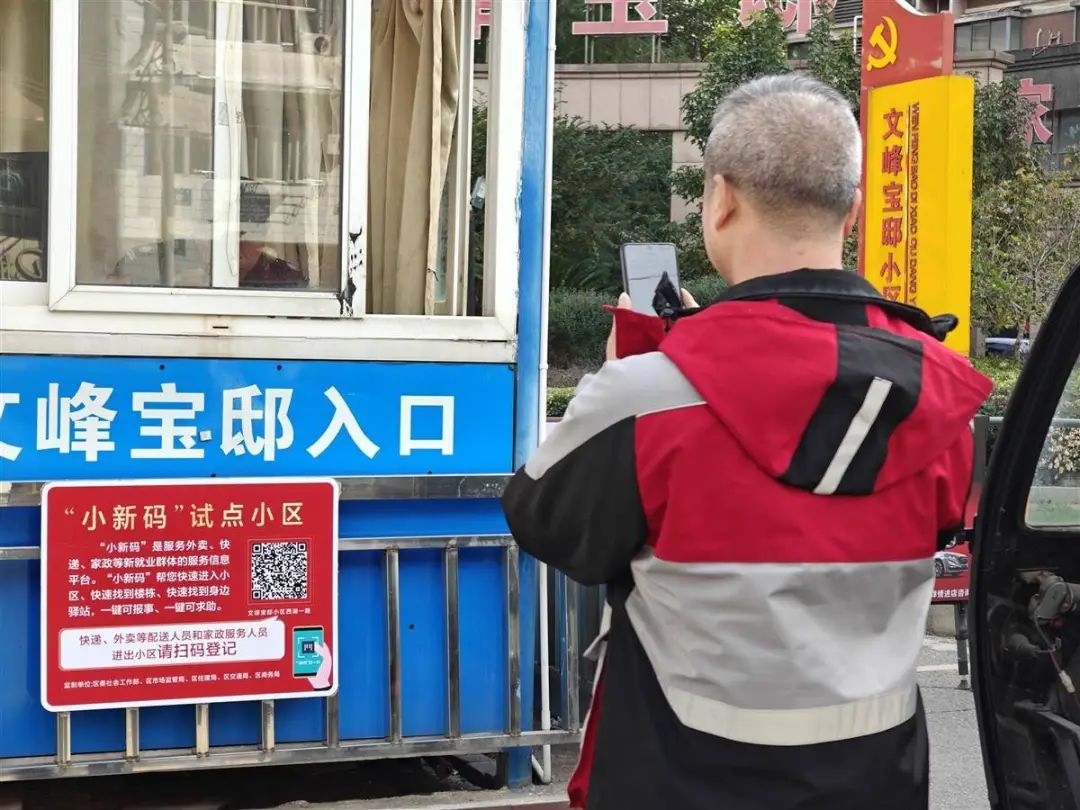 快递小哥通过扫描“小新码”进入小区。（湖北日报全媒记者曹雯摄）
