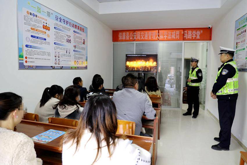 交警组织违法驾驶人在“马路学堂”观看警示教育片。