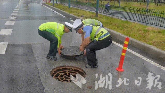 襄阳民警对一移位排水井盖进行复位，及时消除道路安全隐患。