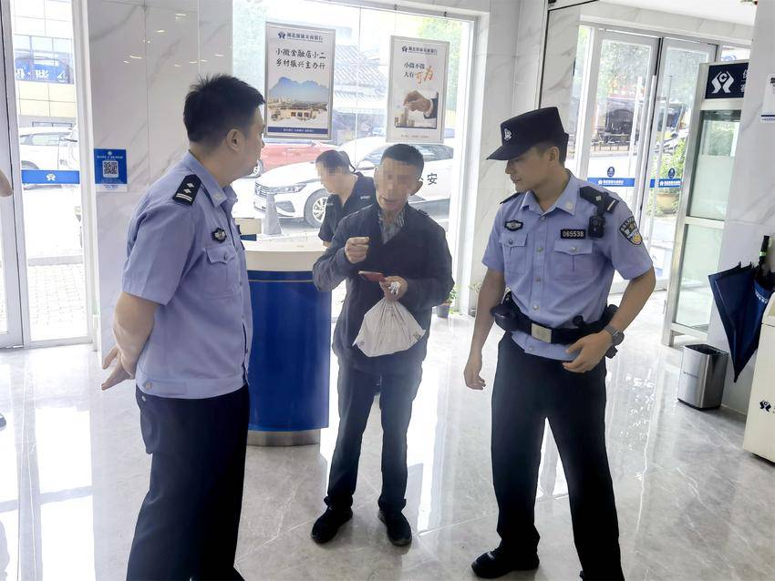 民警陪王大伯在银行存完钱。