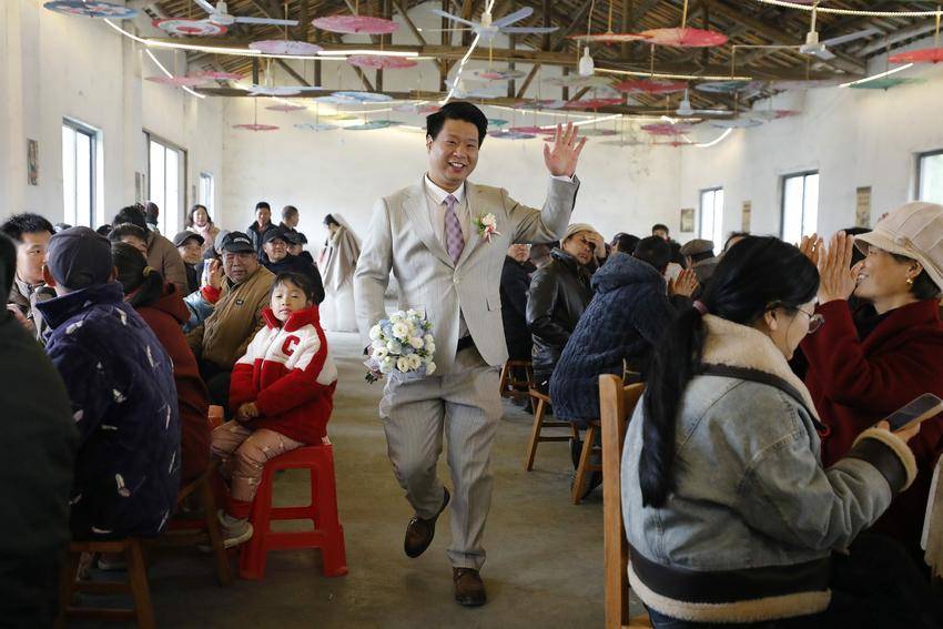 新郎严炳杰在乡亲们掌声中走向婚礼舞台
