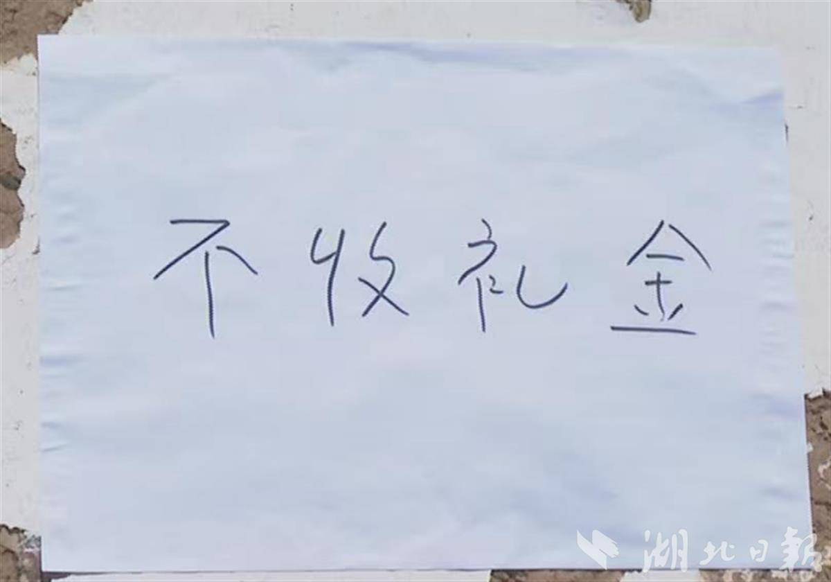 斑驳的墙面上，“不收礼金”四个大家清晰可见