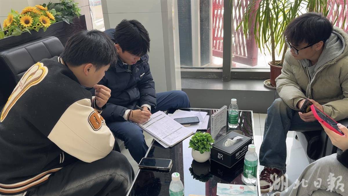 在汉阳区比亚迪汽车4S店，营销代表向客户讲解补贴政策。（左晨、黄雅琦摄）