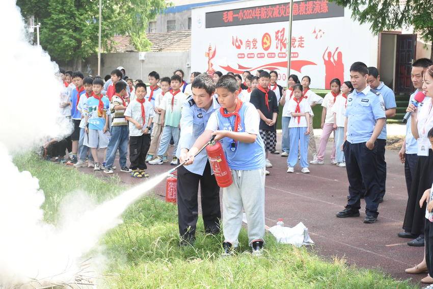 学生在工作人员指导下操作灭火器