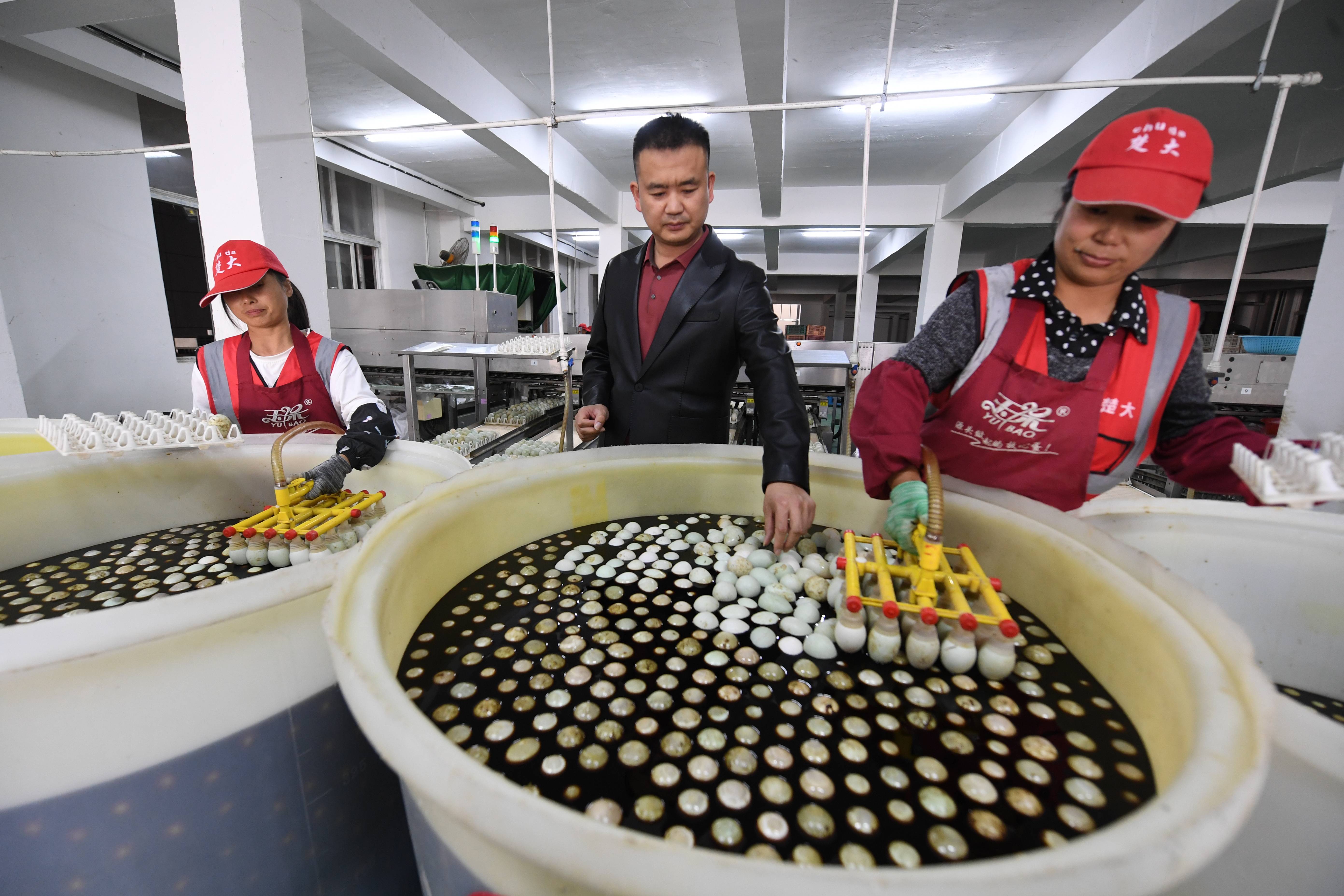 楚大鸭业总经理任乐乐（中）在车间查看生产情况 。（湖北日报全媒记者田悦 通讯员李锋、谢勇 摄）