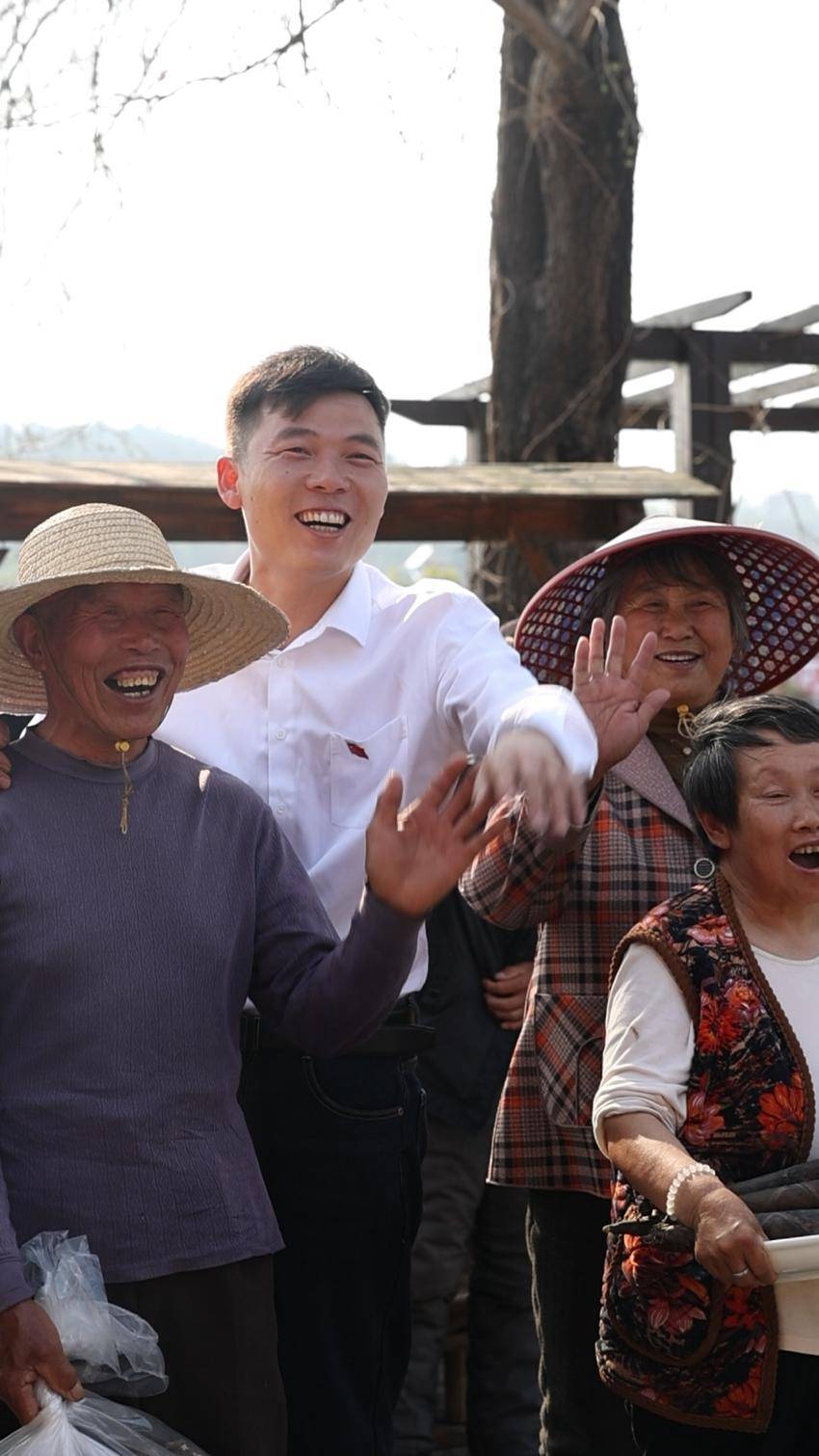 邵谦（左二）在余店镇古城村帮助本地老乡售卖农产品。