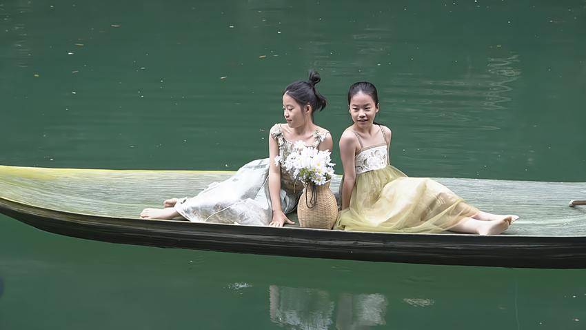 图为游客小朋友体验箬叶船