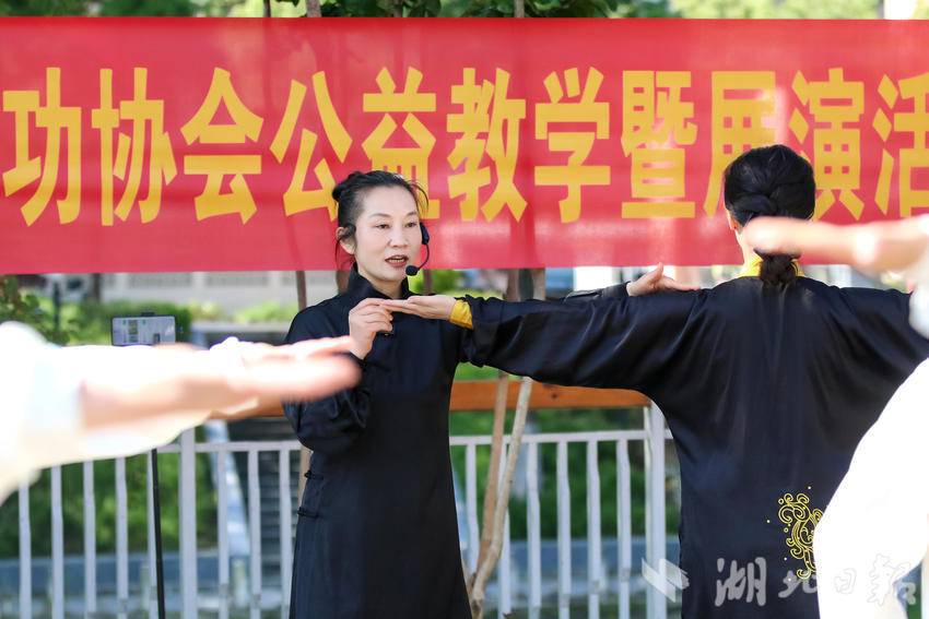 市健身气功协会会长肖寒（图中）为学员手把手示范动作。
