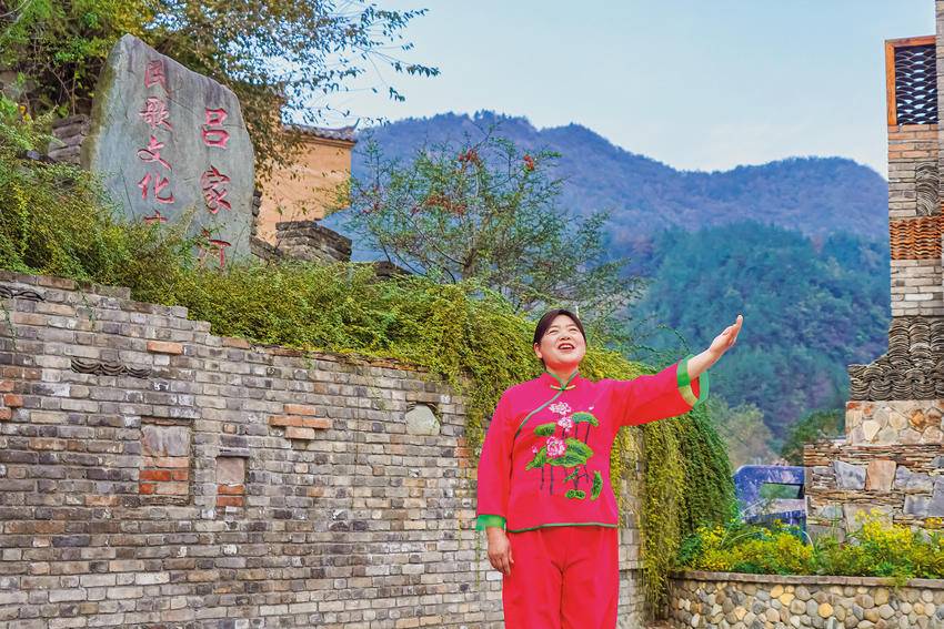 吕家河村村民陈生秀在民歌文化广场前练习民歌