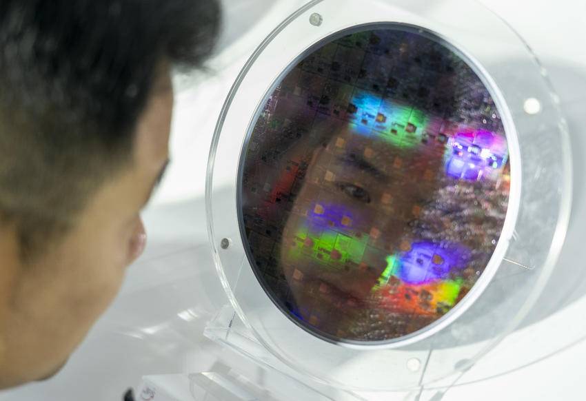 九峰山实验展台，一位观众仔细参观新型化合物半导体晶圆。（湖北日报全媒记者 魏铼 摄）