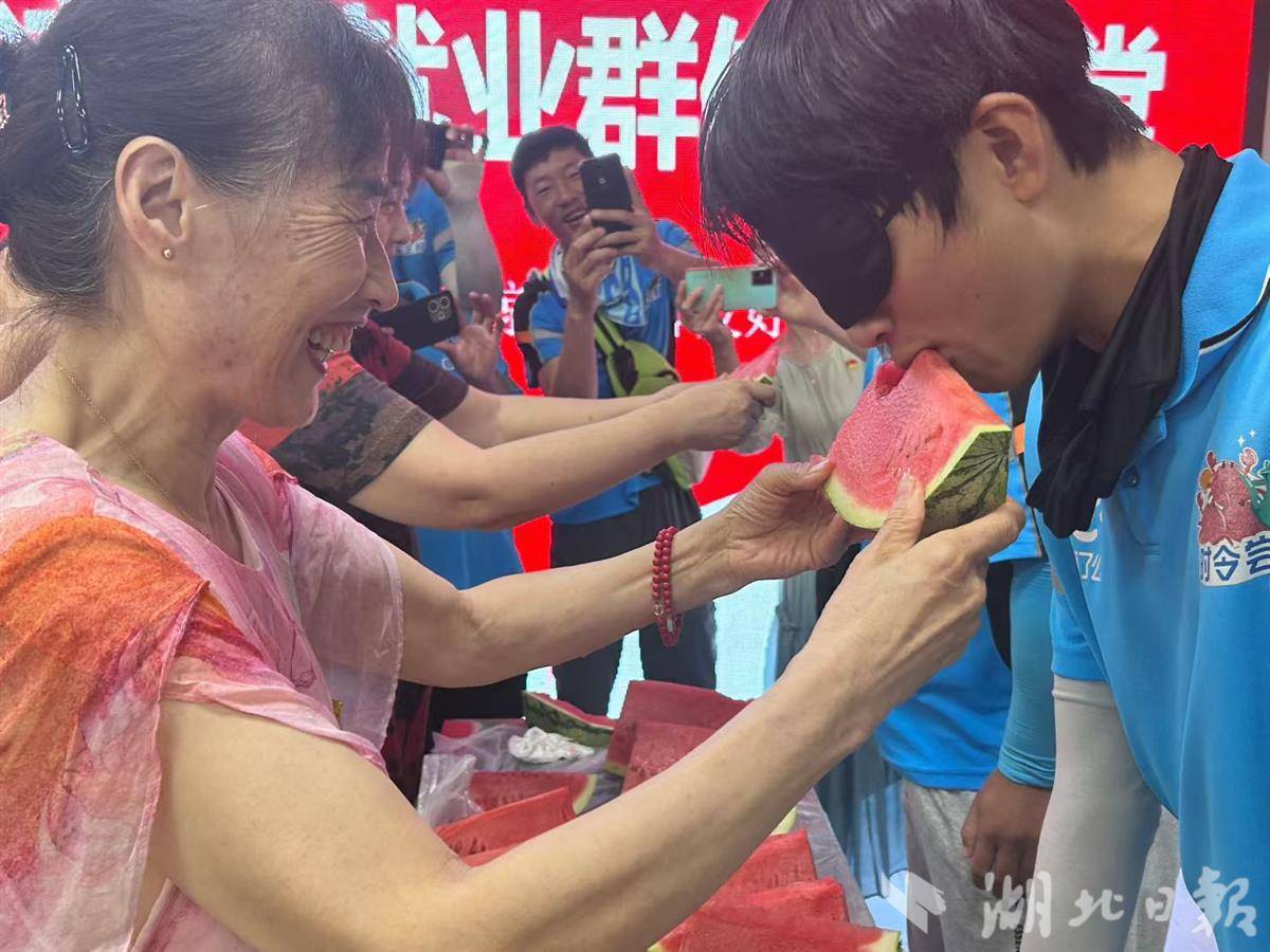 吃西瓜比赛中，小哥们蒙着眼镜吃，党员们端着西瓜喂.jpg