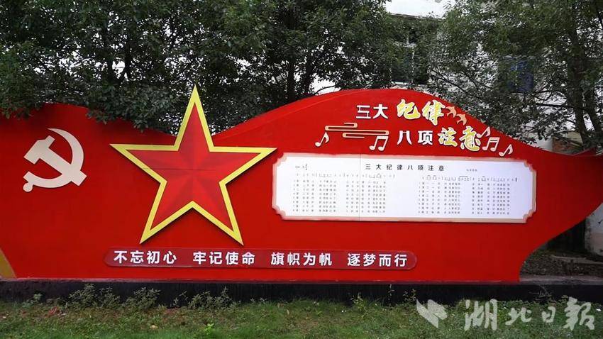大悟县吕王镇刘院村的红色展牌上记录着《三大纪律八项注意》的歌词和曲谱。（湖北日报全媒记者 王欣 通讯员 蔡青阳 摄）
