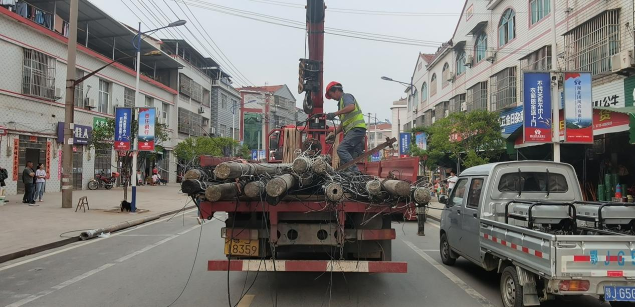 "7月30日,团风县但店镇但店村村民易淑明上街购物时看到被迁移的电杆