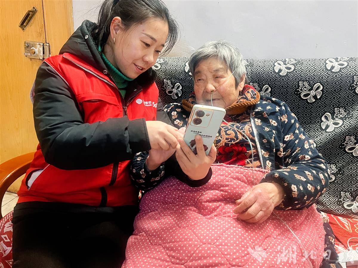 湖北移动志愿者正细心地教老人使用手机，暖心服务助“银发族”跨越数字鸿沟.jpg
