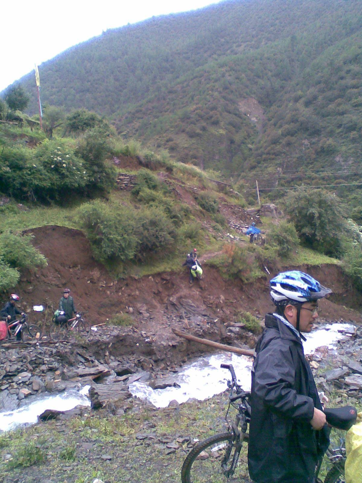 a图像131 318国道维地附近山体滑坡，骑行者搭桥扛着车翻山.jpg