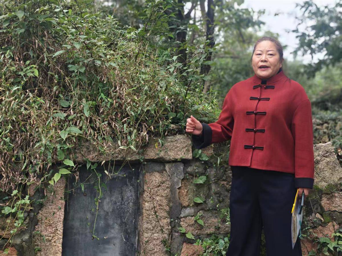在何大妈墓碑前，后人何桂英正在讲述那段往事。（湖北日报全媒记者 曹雯 摄）