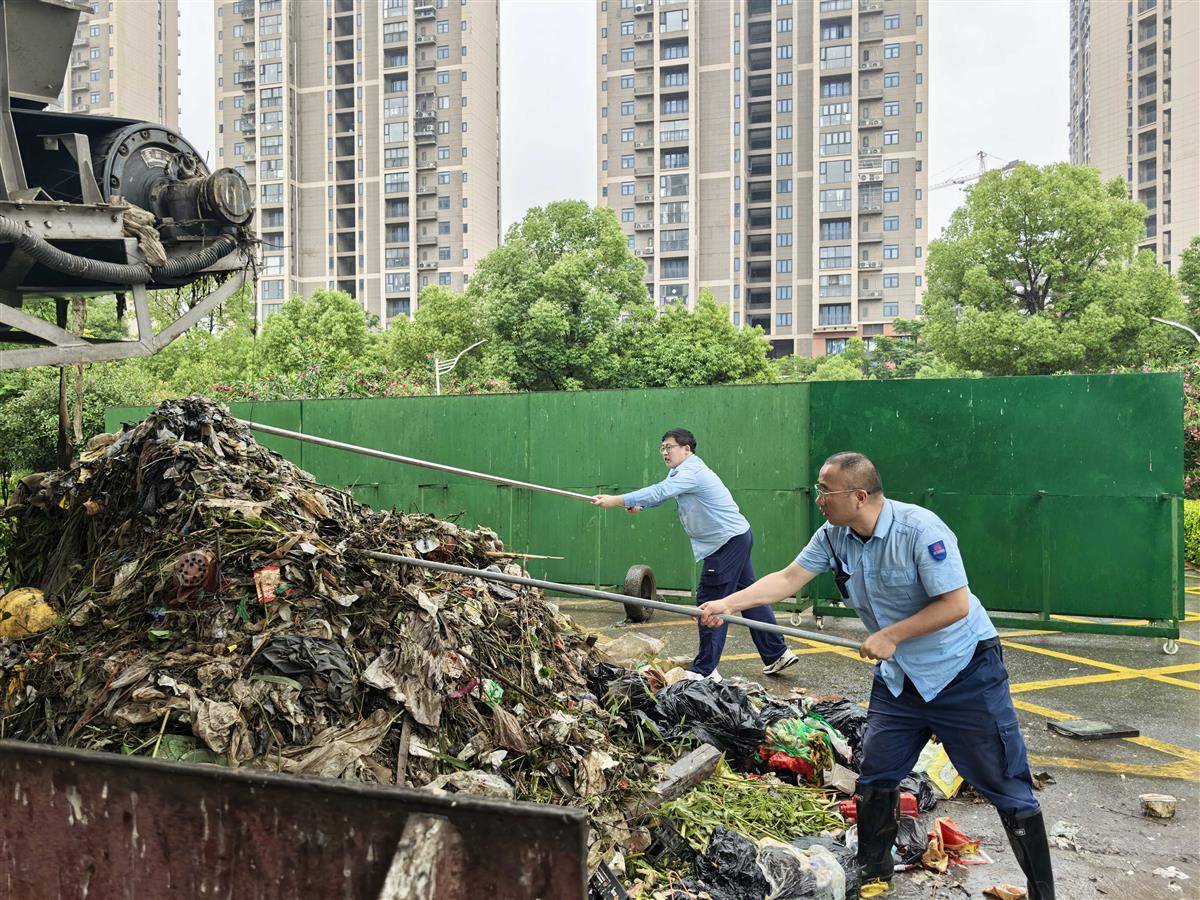 江南泵站工作人员张军和曾庆威，正在清理从泵站前池中清理出来的杂物