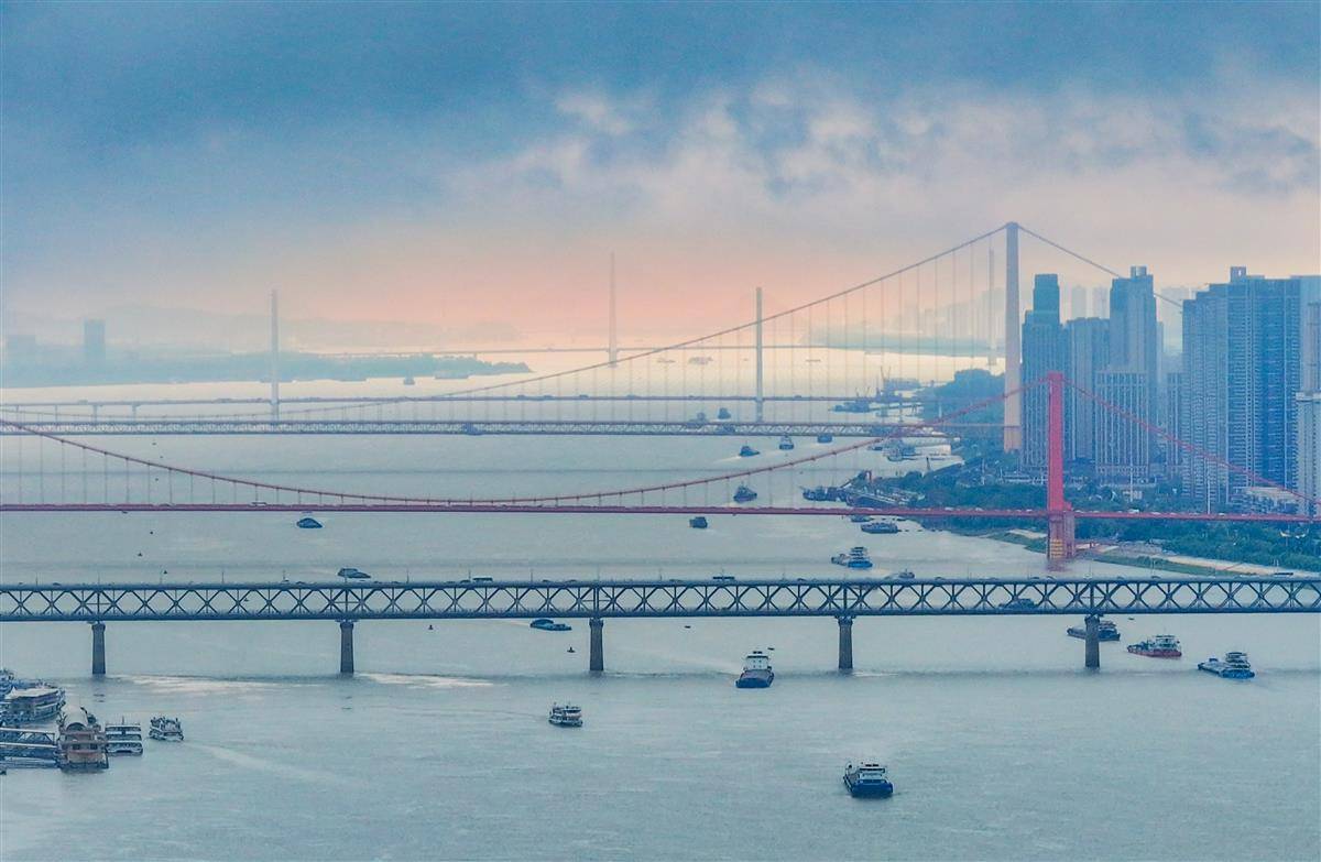 6月7日中午，暴雨过后武汉现“多桥同框”美景。当天武汉遭遇大暴雨，中午暴雨短暂停歇，乌云之下空气通透，能见度极高。从高空俯瞰，5座跨江大桥尽收眼底，高铁、汽车、轮船各行其道。（湖北日报全媒记者 柯皓 摄）