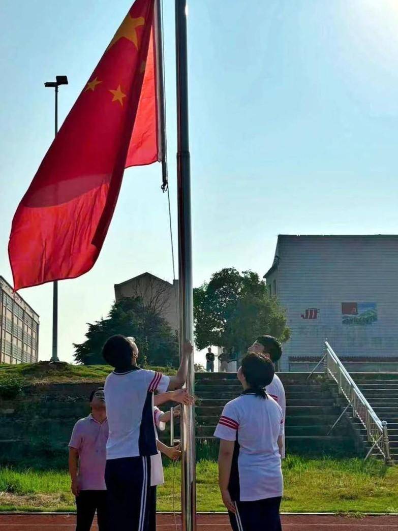 在庄严的国歌声中,五星红旗冉冉升起,全体师生面向国旗肃立,行注目礼